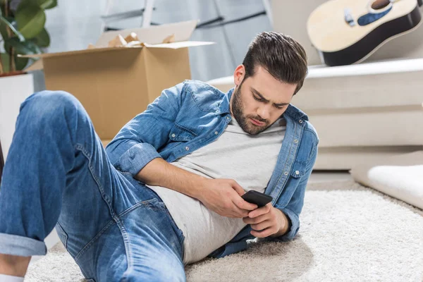 Homem no chão usando smartphone — Fotografia de Stock