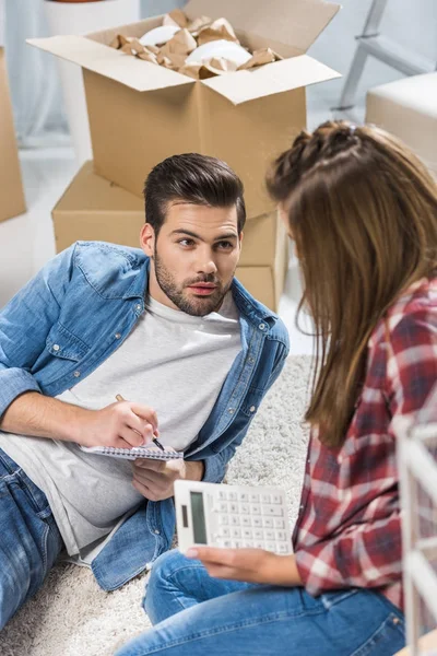 Pareja joven usando calculadora - foto de stock