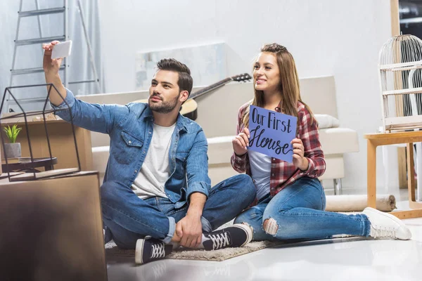 Casal sentado no chão e tomando selfie — Fotografia de Stock