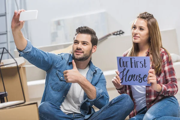 Couple with our first house sign — Stock Photo