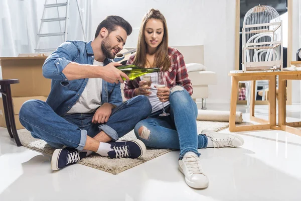 Casal atraente derramando champanhe — Fotografia de Stock