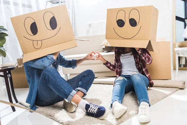 Pareja con cajas en cabezas - foto de stock