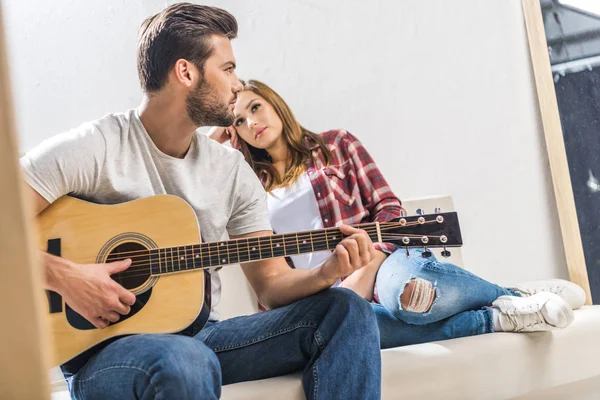 Coppia su divano con chitarra — Foto stock