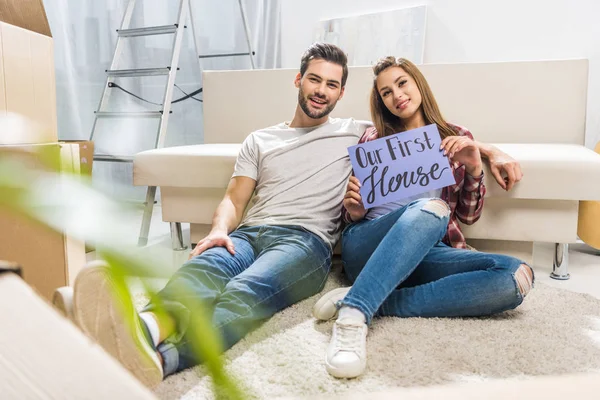 Couple with our first house sign — Stock Photo