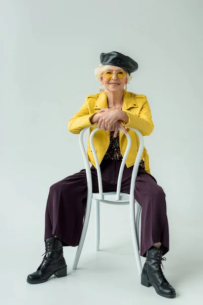 Modische Seniorin sitzt auf Stuhl — Stockfoto