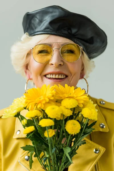 Smiling senior woman with flowers — Stock Photo