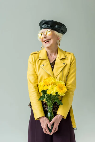 Stylish senior woman with yellow flowers — Stock Photo