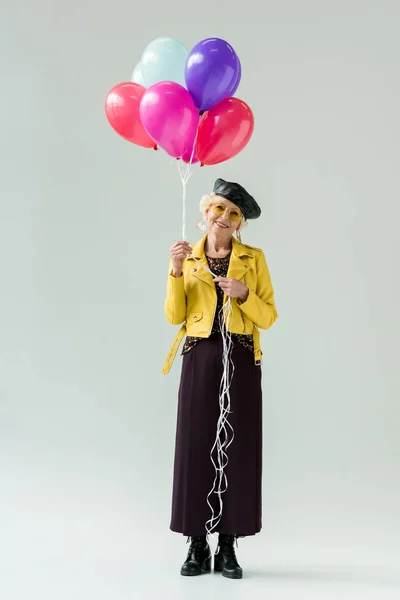 Femme âgée avec des ballons colorés — Photo de stock