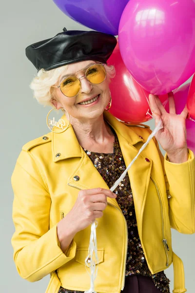 Femme âgée avec des ballons colorés — Photo de stock