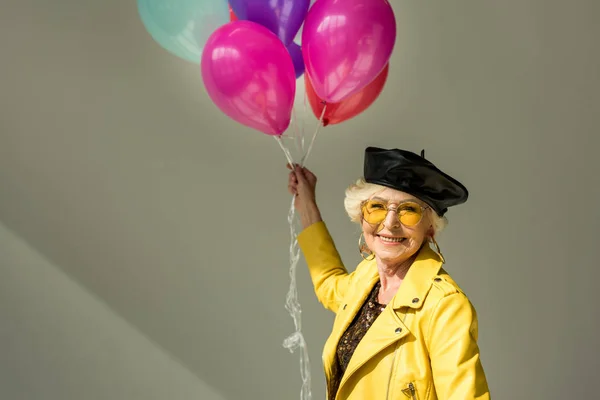 Старша жінка з повітряними кулями — стокове фото