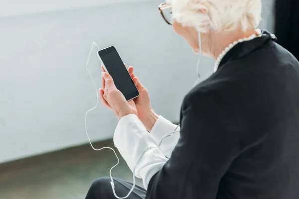 Senhora sênior ouvir música com smartphone — Fotografia de Stock