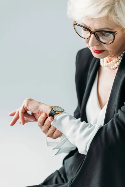 Seniorin schaut auf Uhr — Stockfoto