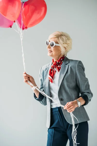 Senior lady with balloons — Stock Photo