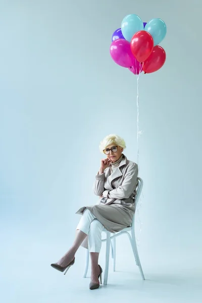 Senior lady with balloons — Stock Photo