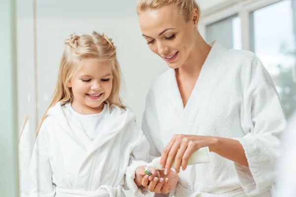 Mother and daughter brushing teeth — Stock Photo