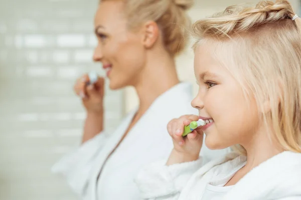 Mère et fille se brossant les dents — Photo de stock