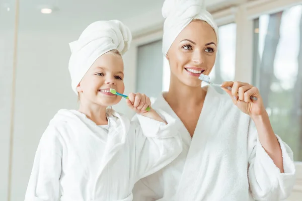 Mother and daughter brushing teeth — Stock Photo