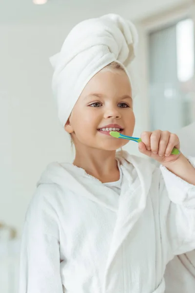 Criança em roupão escovar os dentes — Fotografia de Stock