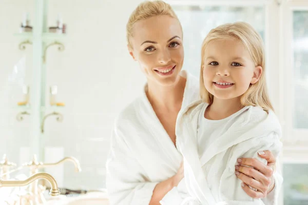 Madre e hija en albornoces - foto de stock