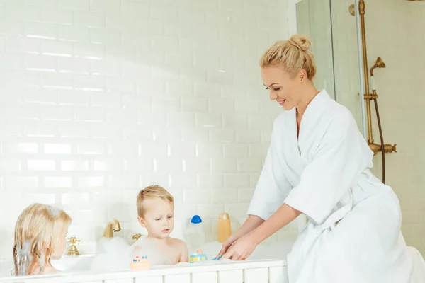 Madre lavare i bambini nella vasca da bagno — Foto stock