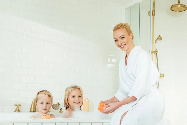 Madre lavare i bambini nella vasca da bagno — Foto stock