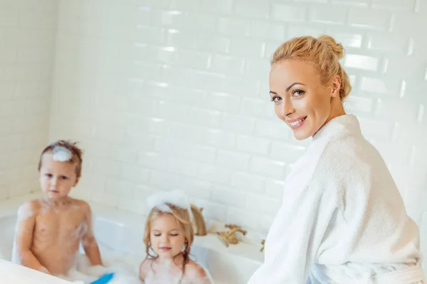 Madre lavando niños en bañera - foto de stock
