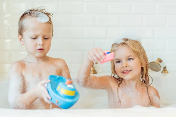 Bambini che giocano nella vasca da bagno con schiuma — Foto stock
