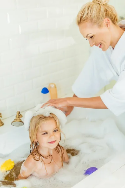 Mother washing daughter in bathtub — Stock Photo