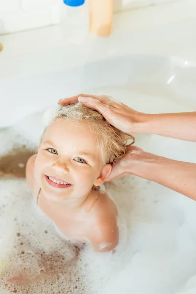 Madre lavaggio figlia nella vasca da bagno — Foto stock