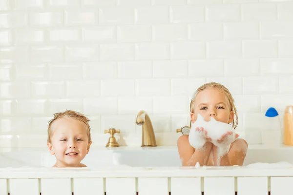 Niños jugando en bañera con espuma - foto de stock