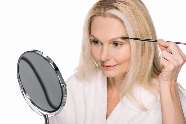 Mature woman using eyebrow brush — Stock Photo