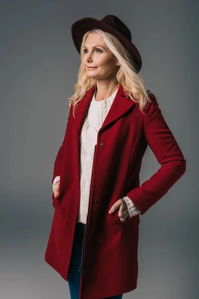 Mature femme en manteau rouge et chapeau — Photo de stock