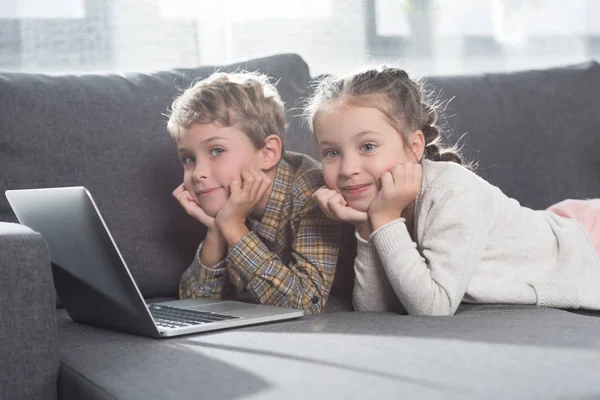 Kinder liegen auf Sofa mit Laptop — Stockfoto