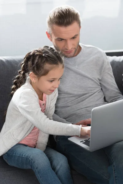 Padre e hija mirando el portátil - foto de stock