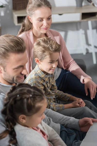 Familie schaut auf Laptop — Stockfoto