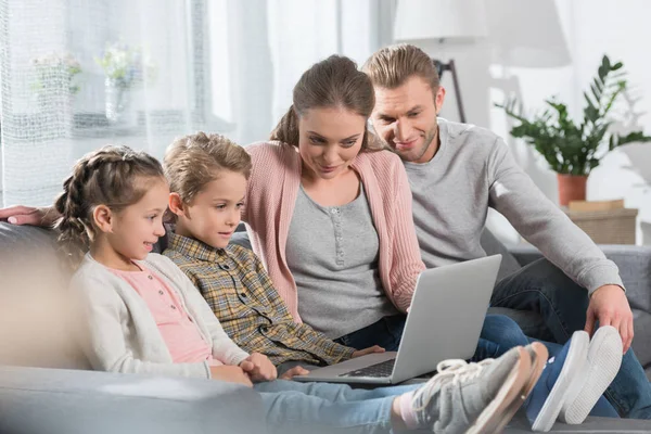 Familia con niños usando laptop - foto de stock