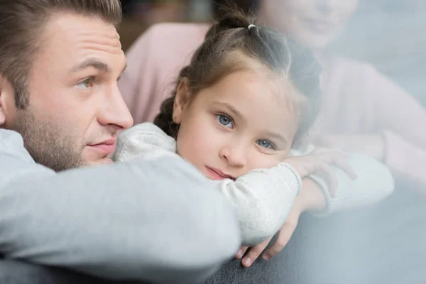 Fille sur le canapé avec les parents — Photo de stock