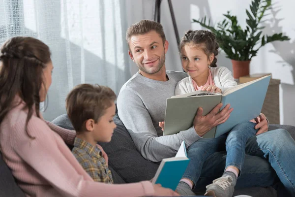 Niños y padres leyendo libros - foto de stock