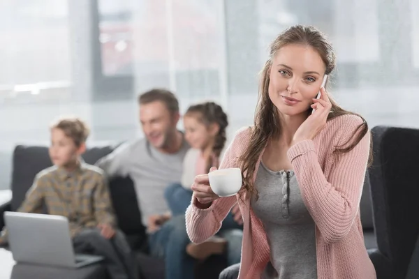 Mujer con café hablando por teléfono en casa - foto de stock