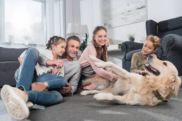 Famiglia che gioca con il cane — Foto stock