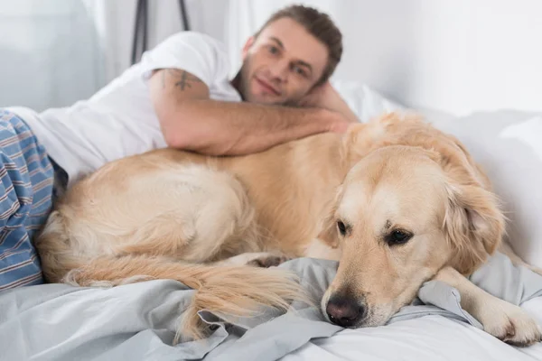 Homem com cão na cama — Fotografia de Stock