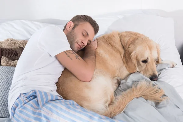 Uomo che dorme e abbraccia cane — Foto stock