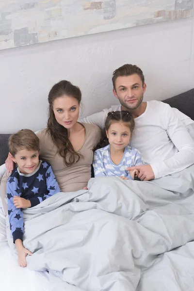 Familia en pijama en la cama - foto de stock