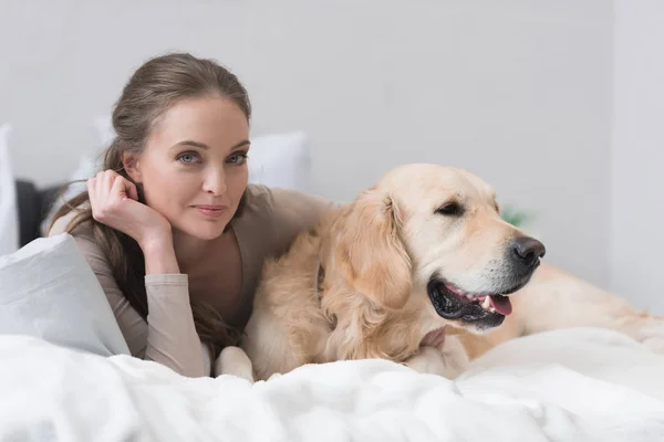 Femme avec chien sur le lit — Photo de stock