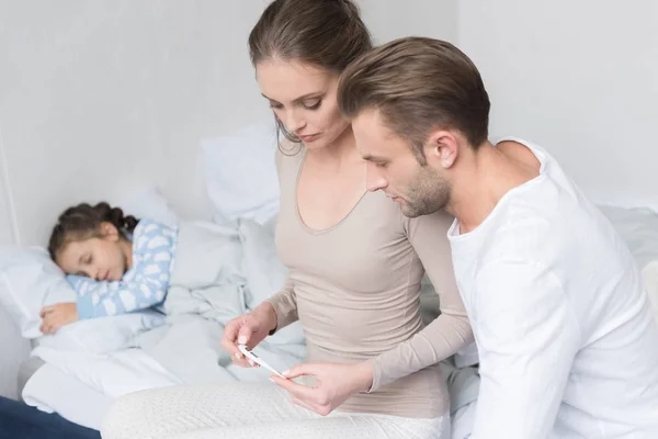 Parents looking at thermometer — Stock Photo