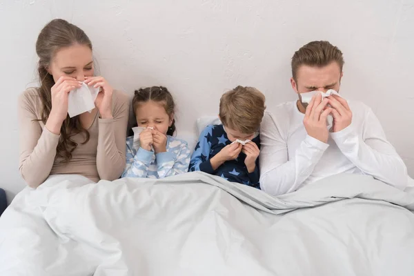 Family blowing noses in napkins — Stock Photo