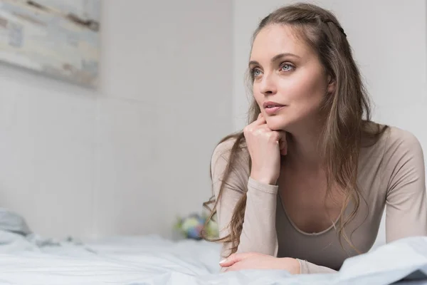 Femme couchée sur le lit — Photo de stock