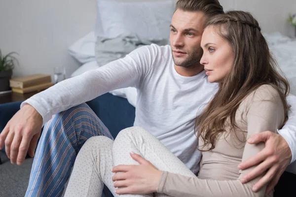 Couple sitting on floor in pajamas — Stock Photo