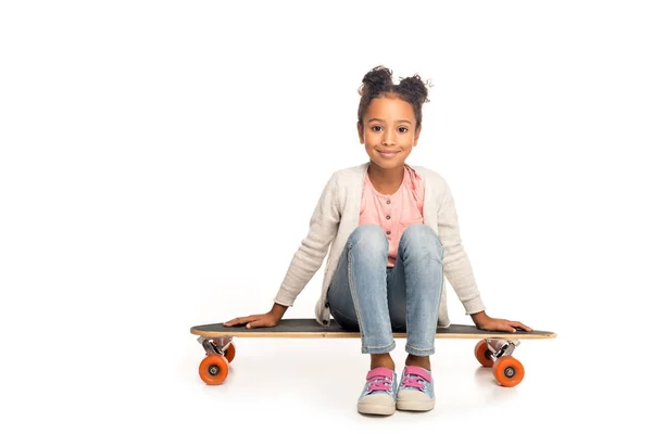 Bambino seduto sullo skateboard — Foto stock