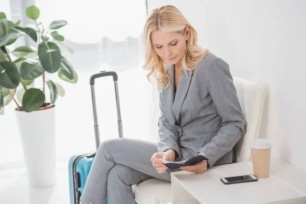 Businesswoman looking at flight ticket — Stock Photo